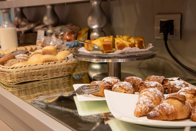 Pictured is part of the buffet. In the foreground are croissants of various types, an apple pie, and various types of bread.